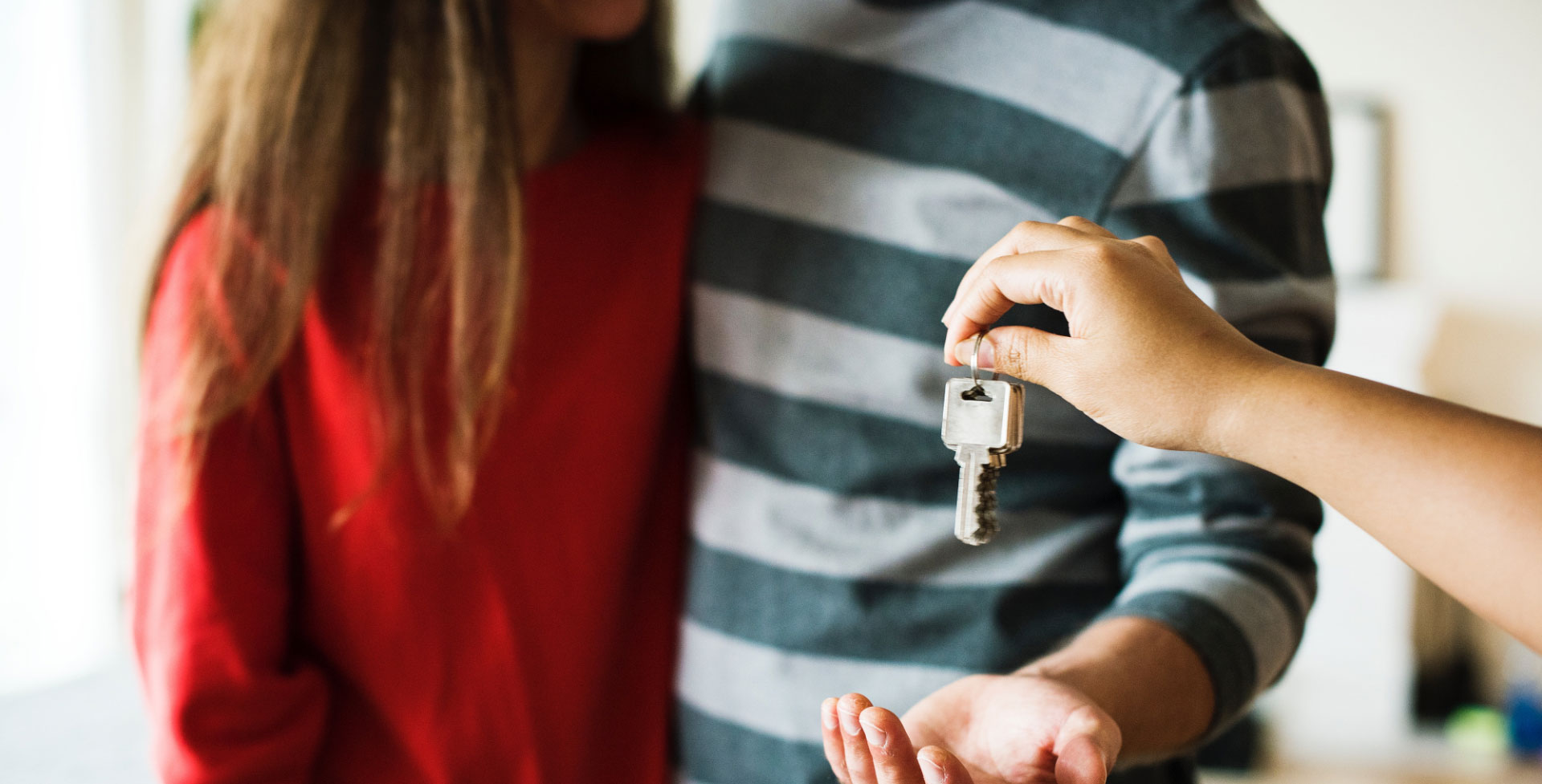 Agent handing keys to buyers